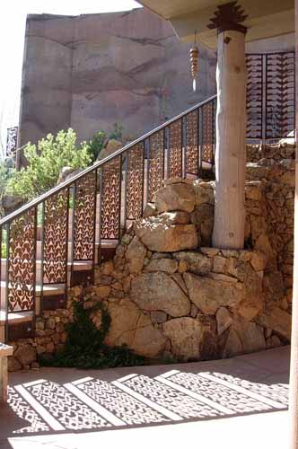 An artistically designed outside metal railing along staircase